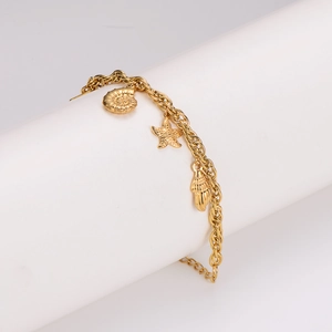 Gold stainless steel link bracelet featuring seashell, starfish, and conch charms on a stand