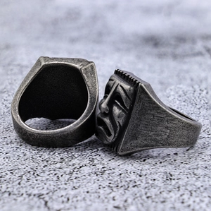 Macro shot of a vintage punk mask ring showing distressed texture and tragedy facial detail