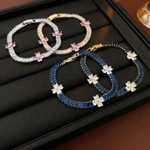 Close-up of four luxury flower bracelets with colorful zircon stones on black velvet display