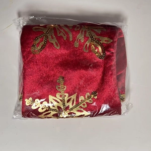 Red velvet Christmas tree skirt with gold sequined snowflakes in clear packaging