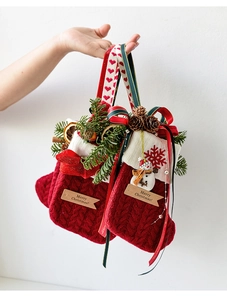 Detalle de calcetín navideño de punto rojo con muñeco de nieve y bordados festivos