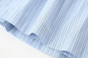 Macro shot of fine blue and white striped cotton fabric with precise stitching details
