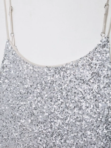Détail de la robe sans manches montrant les paillettes argentées et la fine bretelle