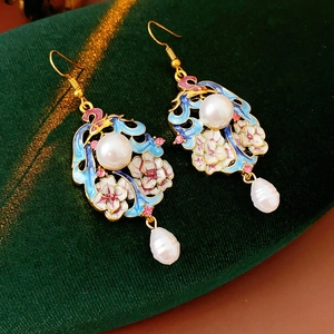 Detail of vintage enamel floral earrings with white pearls and pink flowers on green velvet