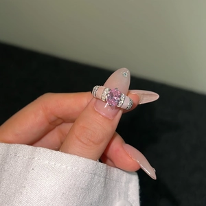 Macro shot of silver ring with pink oval gemstone and sparkling micro-pave details
