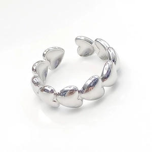 Close-up of a silver stainless steel open ring with interlocking heart-shaped design