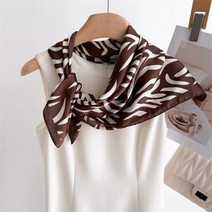 Classic brown and white zebra print silk scarf tied on a white sleeveless top