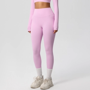 Detail view of pink high-waisted yoga leggings with functional side pockets and soft texture