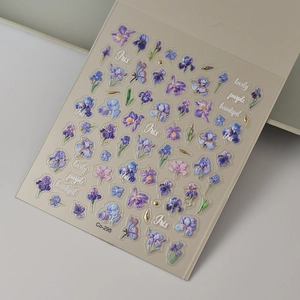 Detail of 5D embossed nail stickers featuring purple iris flowers and golden outlines