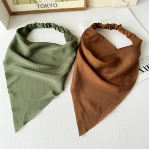 Detail view of silk satin headbands in olive green and brown with elastic bands