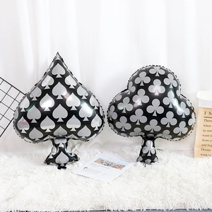 Detail of spade and club poker foil balloons with silver patterns on black background
