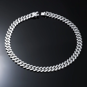 Detailed view of silver polished Cuban link chain necklace on a black reflective surface