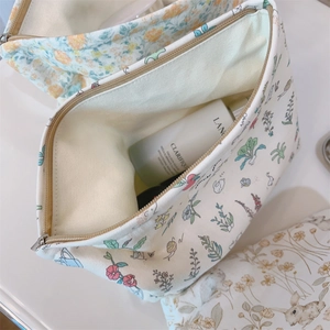Top view of floral canvas makeup bag with rabbit prints and zipper closure details