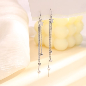 Close-up of silver star tassel earrings with delicate metal beads on white display