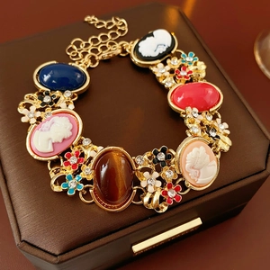 Detail of vintage cameo bracelet with colorful enamel flowers and faux gemstone charms