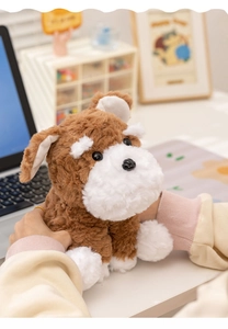 Close-up of curly lamb velvet plush Schnauzer dog toy held in hands on a cozy desk
