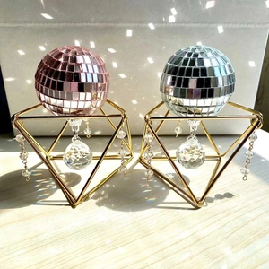 Pink and silver disco ball ornaments with gold geometric stands and crystal charms
