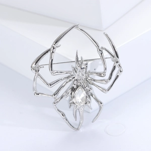 Detailed macro view of a silver spider brooch with a sparkling clear crystal raindrop