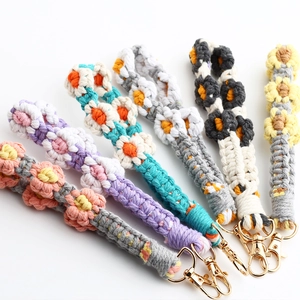 Close-up of handmade crochet daisy keychains in various colors with metal lobster clasps
