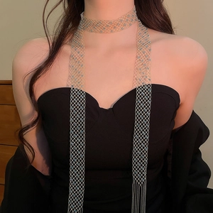 Detail of elegant gold mesh body chain necklace with light blue beads and tassels