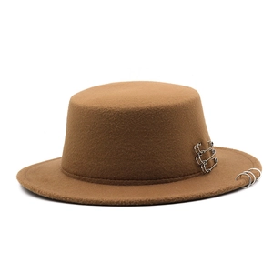 Detail of brown wool fedora featuring silver metal rings and safety pins accessories