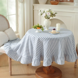 Detailed view of the blue and white striped round cotton tablecloth with ruffled edges