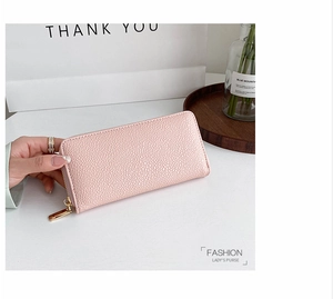 Close-up of pink pebbled leather long purse with gold zipper and stylish inner compartments