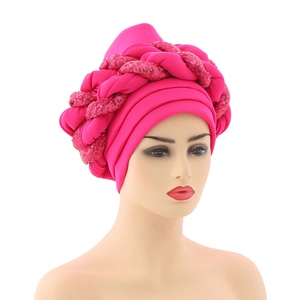 Close-up of rose red African turban hat featuring multi-layer wrap and sequin braid detail