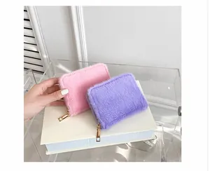 Nahaufnahme flauschiger Plüsch-Geldbeutel in Rosa und Lila mit goldener Reißverschluss