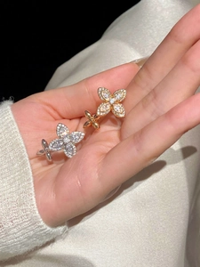 Close-up of golden and silver floral rings with sparkling zircon inlay on palm