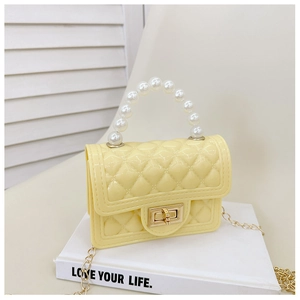 Close-up of yellow quilted jelly bag featuring pearl handle and golden chain strap