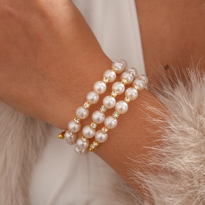 Detail of layered pearl bracelet featuring sparkling rhinestone-encrusted gold spacers