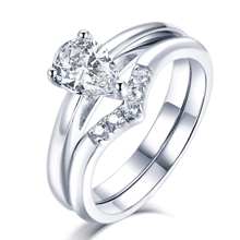 Macro detail of pear-cut diamond ring set with V-shaped pavé band in silver finish