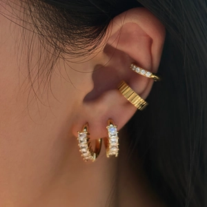 Close-up of minimalist gold titanium steel earring set with square zircon on model ear