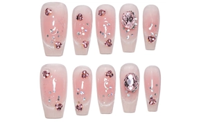 Detail of pink gradient press-on nails with heart rhinestones and oval pink gems