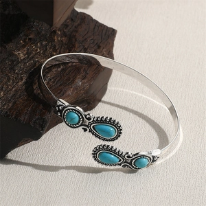 Close-up of bohemian silver alloy cuff bracelet with turquoise stones on wood