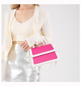 Close-up of a pink and white contrast handbag featuring a textured leather finish