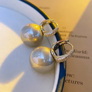 French style pearl earrings with gold zirconia buckle displayed on a white tray