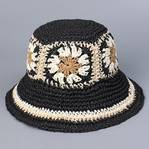 Detail of handmade straw hat featuring crochet sun flower patterns and woven texture