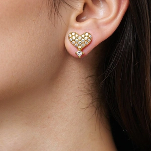 Elegant gold heart stud earrings with white cubic zirconia pavé stones on model