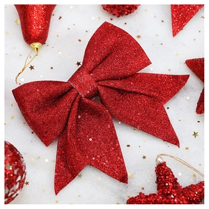 Sparkling red sequin bow ornament with glitter finish on white snowy background