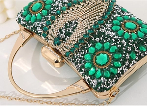 Detailed macro view of green and clear crystals set on a gold metal evening clutch bag