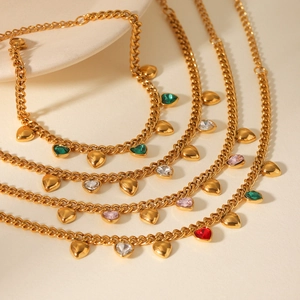 Détail de bracelets gourmettes dorés 18 carats avec breloques cœurs en zircon coloré