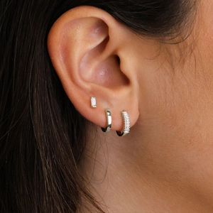 Detail of silver S925 earring set featuring rectangular crystals and paved hoops on ear