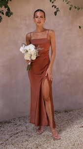 Detail of elegant satin dress in copper brown featuring a side slit and sleek straps