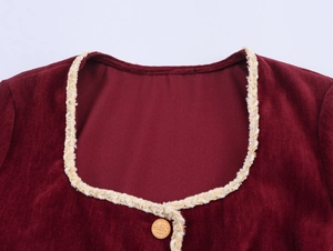 Detail of burgundy velvet dress featuring square neckline and pearl button decoration