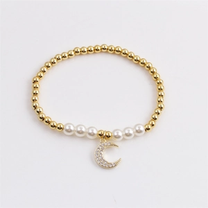 Elegant gold plated pearl bracelet with a sparkling zircon moon charm on a white background