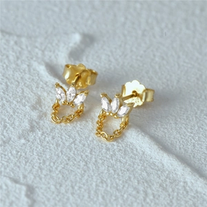 Macro detail of S925 sterling silver gold earrings with marquise zircon and chain tassels
