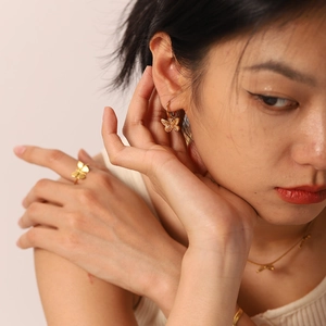 Elegant gold butterfly jewelry set including necklace, ring, and earrings on female model