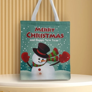 Detail of green Christmas canvas tote bag featuring snowman print and festive greetings